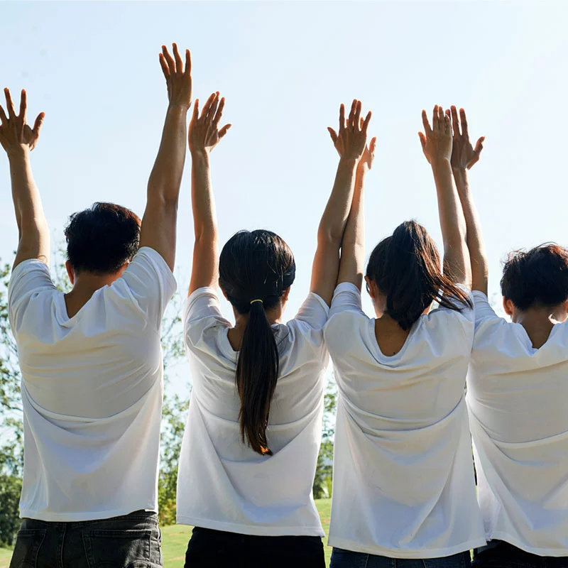 four Optima employees viewed from behind with hands raised in celebration